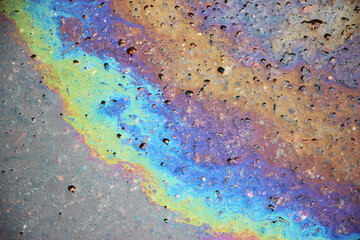 Oil spill on asphalt road background or texture