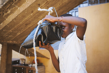 Girl drinks water from bucket