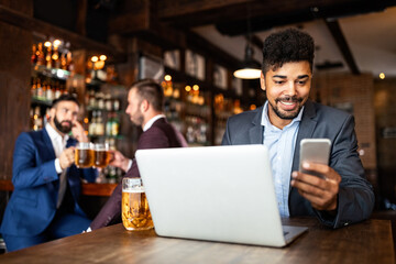Portrait of a successful business man sitting at the cafe working on a laptop.