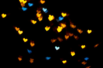 Yellow gold and blue heart-shaped on black background Colorful lighting bokeh for decoration Valentine, Love Pictures background