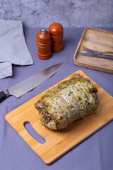 Turkey thigh on the bone, baked with mustard, parsley, spices and chili on a wooden board. Close-up.