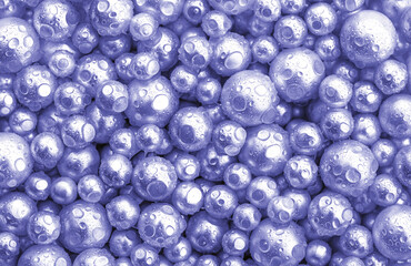 Beautiful background with mother-of-pearl pearls, top view.Violet and silver colors. Demonstrating color of 2022 year. Abstract texture for festive backgrounds. Shiny surface of Christmas decorations.
