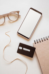 Online shopping smartphone and credit card flat lay beige background