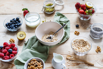 Healthy breakfast concept with oat flakes, fruits, yogurt, nuts, berries, chia seeds
