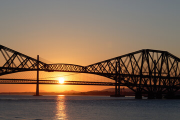 Fototapeta na wymiar Sun setting behind Forth Rail and Road Bridges