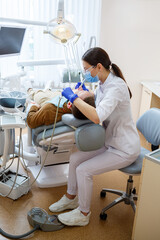 Doctor woman dentist treats the patient's teeth, proper dental care. Dental care and hygiene concept. Selective focus.