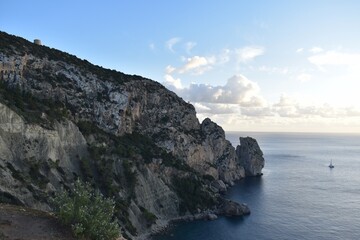 Fototapeta na wymiar Rocks in the sea and a boat in the coast of Ibiza