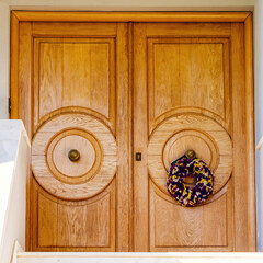 Christmas wreath decorated house entrance natural wood doors, Athens, Greece.