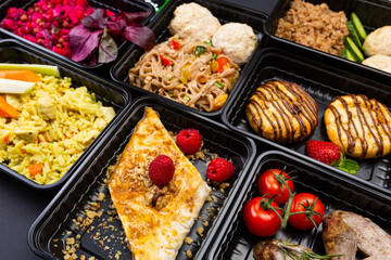 Ready healthy food catering menu in lunch boxes meat and vegetable packages on black table background