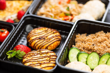 Ready healthy food catering menu in lunch boxes meat and vegetable packages on black table background