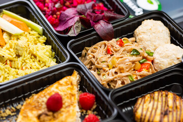 Ready healthy food catering menu in lunch boxes meat and vegetable packages on black table background