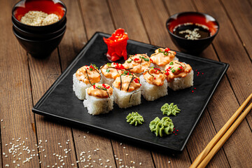 Cheese ebi sushi rolls with wasabi and soy sauce on wooden background