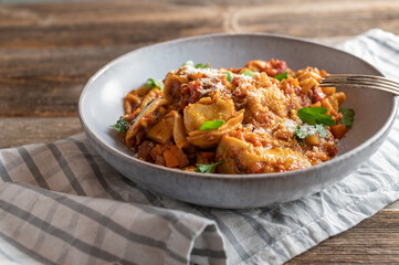 Plate with tortellini in a tomato, vegetable sauce with parmesan cheese