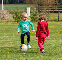 Chłopiec i dziewczynka grają w piłkę - obrazy, fototapety, plakaty