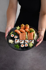 Woman hand holding a Sushi Mix plate