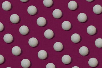 White Christmas bulbe as pattern on red violet colored background.