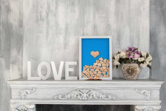 Composition for Valentine's, Mother's or Women's Day. Blue picture with wooden heart on old gray white background. Still-life.