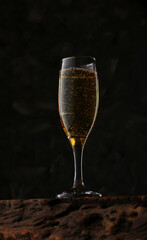 a glass of festive champagne on a textured wooden table