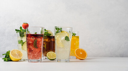Set of various summer refreshing lemonades. Lime, strawberry, cuba libre, lemon, orange drinks with ice on light background