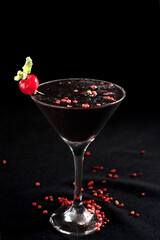 refreshing alcoholic drink with berries, ice vodka and gin, absinthe lemon peel served in glass cup on the counter on black background