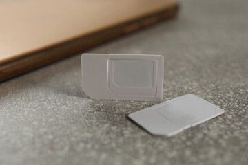 White multi SIM cards on grey table, closeup