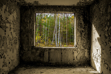View through the hole for a windows in a damaged abandoned panel house.