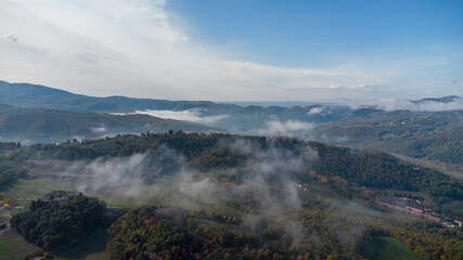 Drone shot of the landscape in Umbria in Italy. Sunrise with fog in the valley. High quality photo