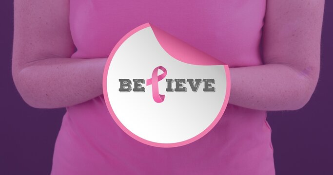 Composite image of woman with breast cancer awareness ribbon and believe text