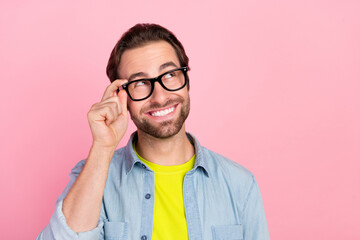 Photo of young cheerful man hand touch eyeglasses dreamy wonder look empty space isolated over pink...