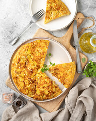 Frittata or potato pie in a ceramic plate on a light culinary background. Traditional Italian delicious homemade egg dish on the kitchen table. Top view