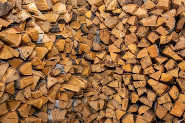 Solid textured surface made of chopped wood (logs). Fuel supply for heating a residential village house.