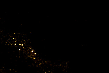 Golden blurred bokeh lights on black background. Glitter sparkle stars for celebrate. Overlay for your design