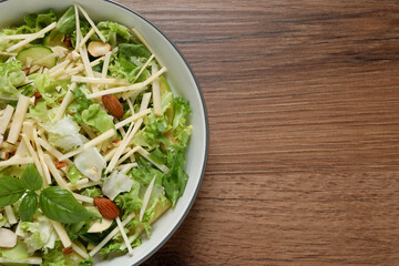 Delicious turnip salad served on wooden table, top view. Space for text
