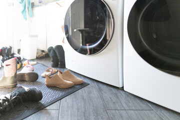 Dirty laundry room interior and home entrance with shoes and clutter