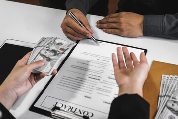 businessman's hand or corrupt politicians is offering bribes that are given in the form of dollar cash To do illegal business, corruption in the contracting business, corruption concept and bribery.