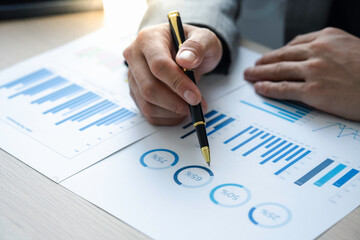 male finance staff Is explaining the performance from the company's rapidly growing bar graph this year. To his boss On the desk at the office, Finance concept