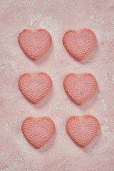 Fototapeta premium Valentine day decorated heart shaped cookies on pink background, top view