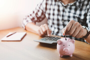 Obraz na płótnie Canvas image of man hand putting coins in pink piggy bank for account save money. Planning step up, saving money for future plan, retirement fund. Business investment-finance accounting concept.