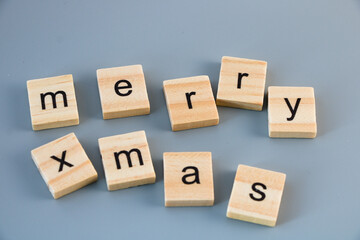 Merry xmas message on wooden tiles isolated on grey background