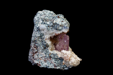 macro mineral amethyst stone in rock on a black background