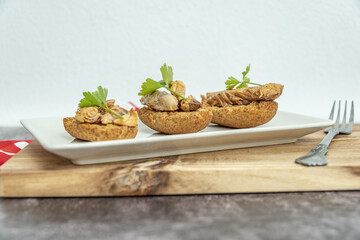 Plate of toasted bread with mackerel in pickled sauce, a typical Spanish tapa.