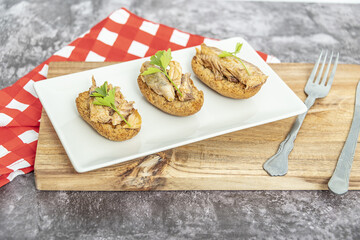 Plate of toasted bread with mackerel in pickled sauce, a typical Spanish tapa.