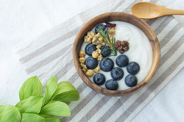 Bowl of yogurt with wild berries and fruit on white background.
