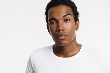 Young black man dressed white t-shirt posing and looking at camera
