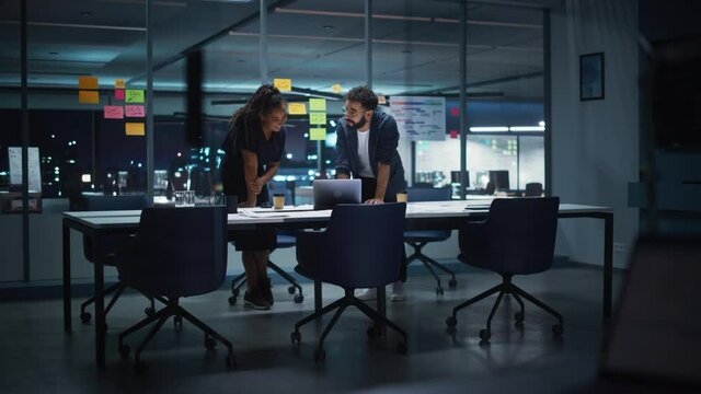 Businesspeople in Modern Office: Business Meeting of Two Managers. Female CEO and Marketing Director Talk, Brainstorm Corporate Strategy, Implementing Marketing and Financial Plans. Evening Time.