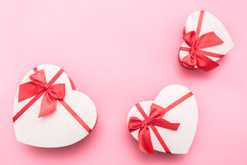 Love Valentine's Day. Love background. Gifts in the form of hearts on a pink background with the...