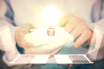 Double exposure of man's hands holding and using a digital device and bulb hologram drawing. Idea concept.