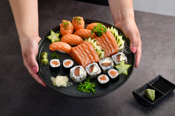 Woman hand holding a sushi mix plate