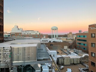 Falls Church, Virginia, USA - December 14, 2021: Interior buildings of INOVA Fairfax Hospital as seen at sunrise from a patient’s room featuring the water tower