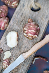 Sliced Jerusalem artichokes on wooden cutting board